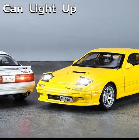 Yellow and white toy cars with headlights on, displayed side by side.