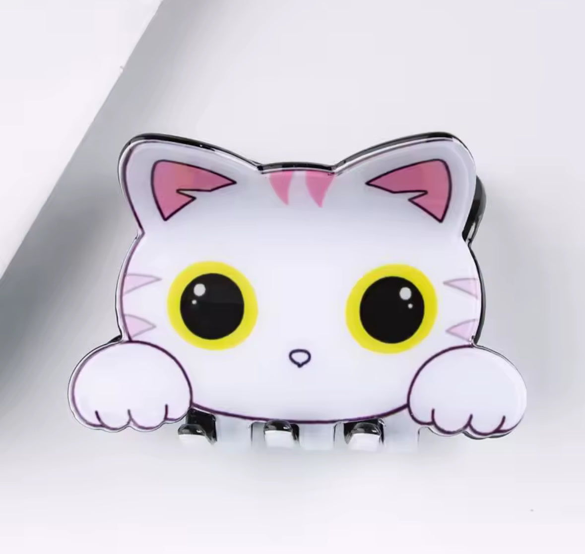 Cute cartoon cat hair clip with big eyes and pink ears.