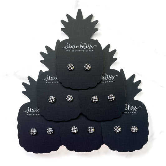 Black pineapple-shaped display cards with Dixie Bliss earrings.