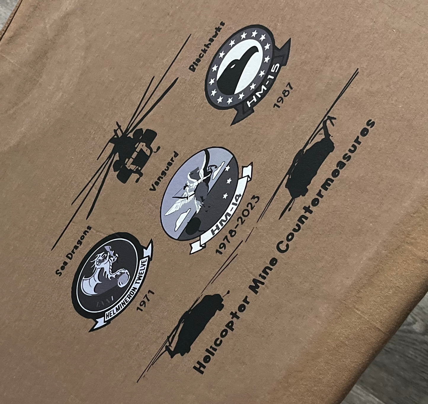 Vintage military helicopter mine countermeasures patches on brown fabric.