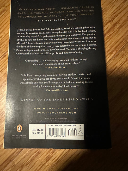 Back cover of The Omnivores Dilemma by Michael Pollan, featuring book details and reviews.