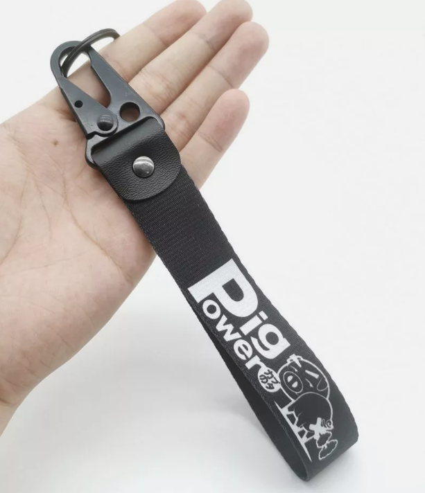 Black keychain with Pig Power and cartoon pig design.