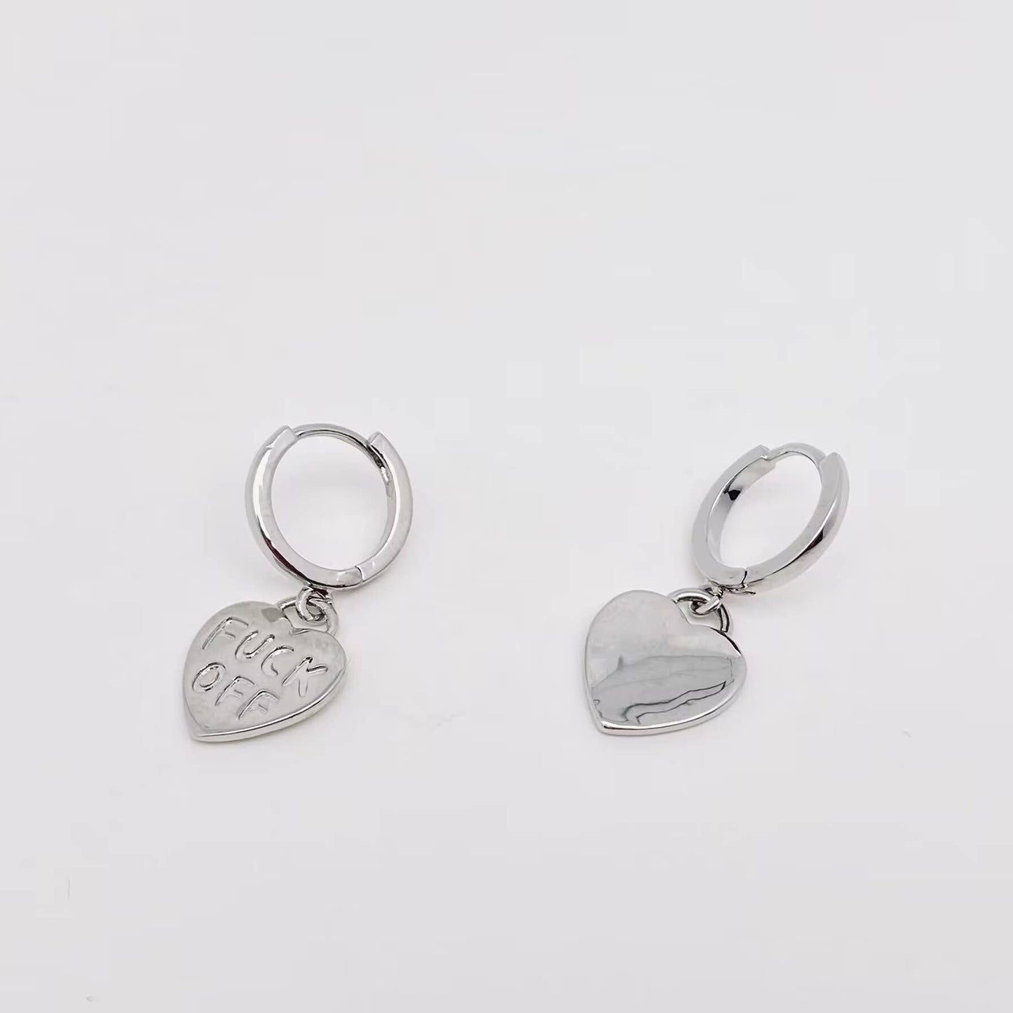 Silver heart-shaped earrings with engraved text and polished finish.