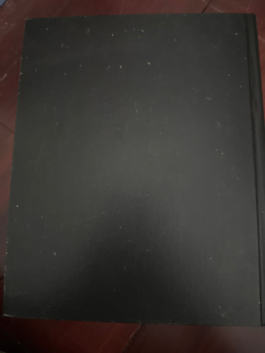 Black rectangular object with dust on a red surface.
