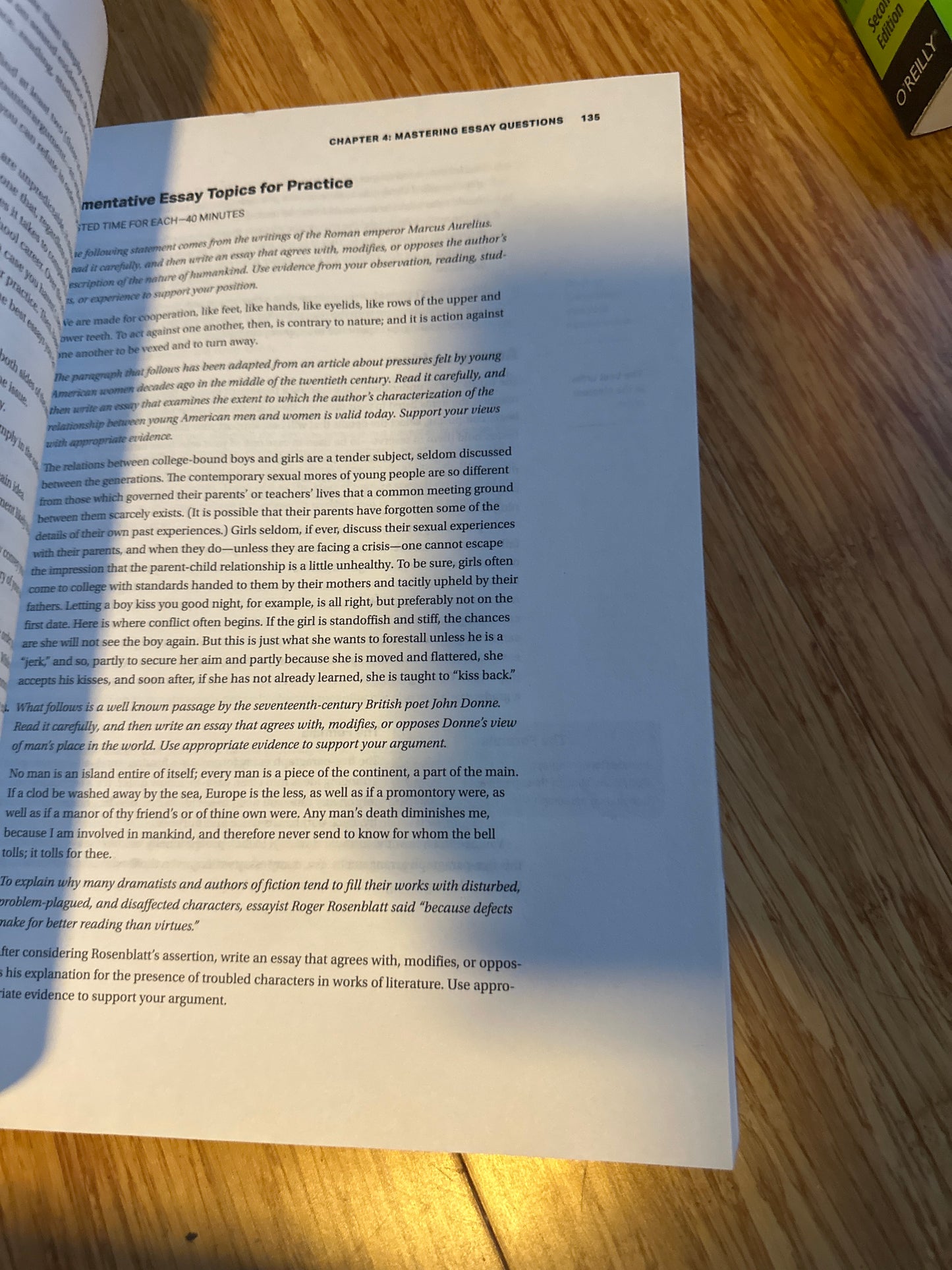 Open book with essay questions on a wooden table.