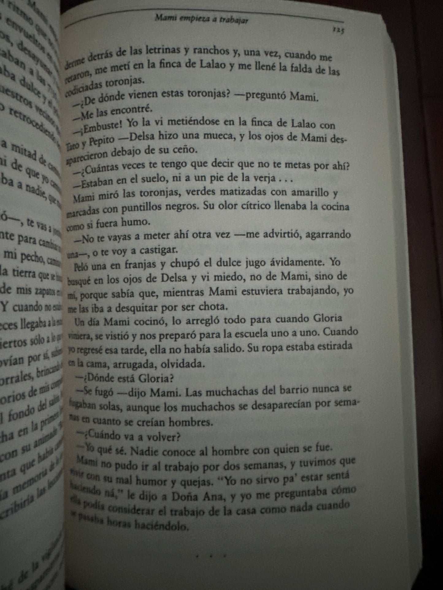 Open book page with Spanish text, dark background.