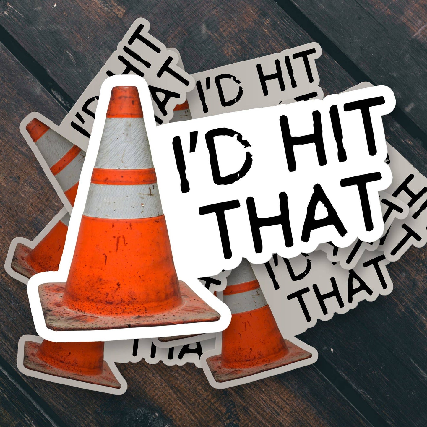 Orange traffic cone sticker with Id Hit That text on a wooden surface.