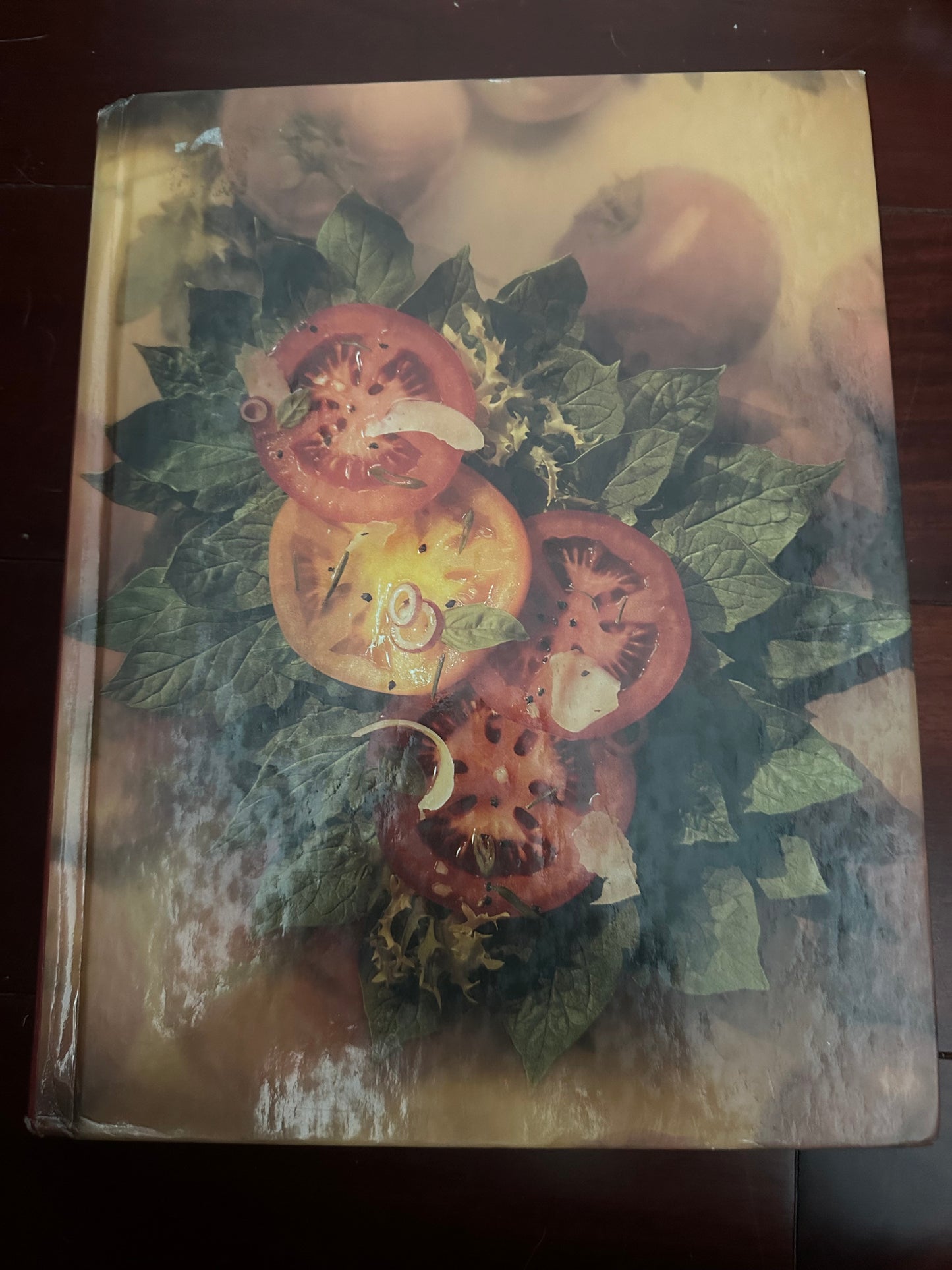 Sliced heirloom tomatoes with green leaves on a wooden surface.