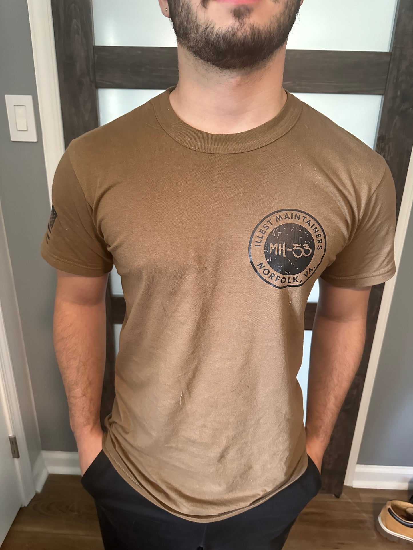 Man wearing brown t-shirt with Illest Maintainers logo.