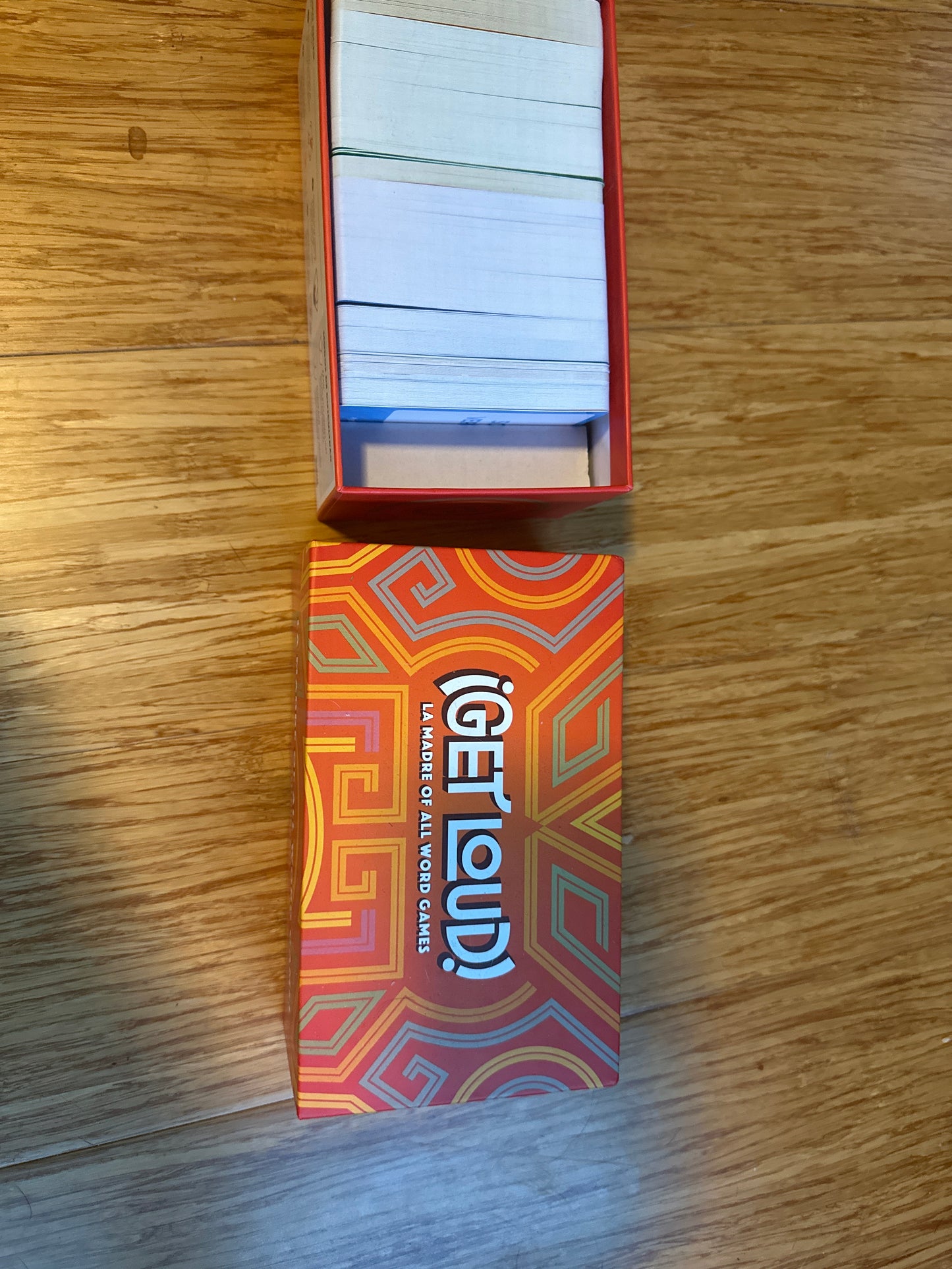 Get Loud word game box with cards inside on wooden surface.