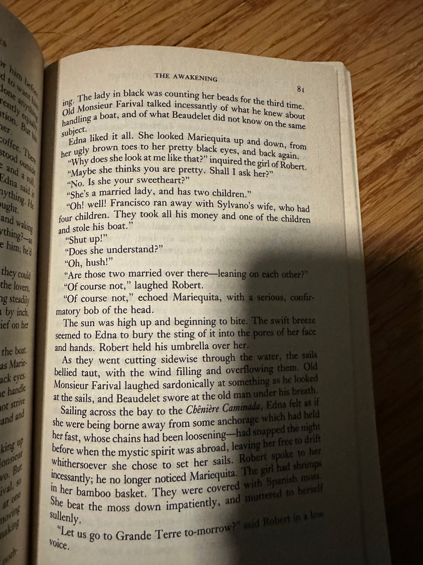 Open book titled The Awakening on wooden surface, page 81.