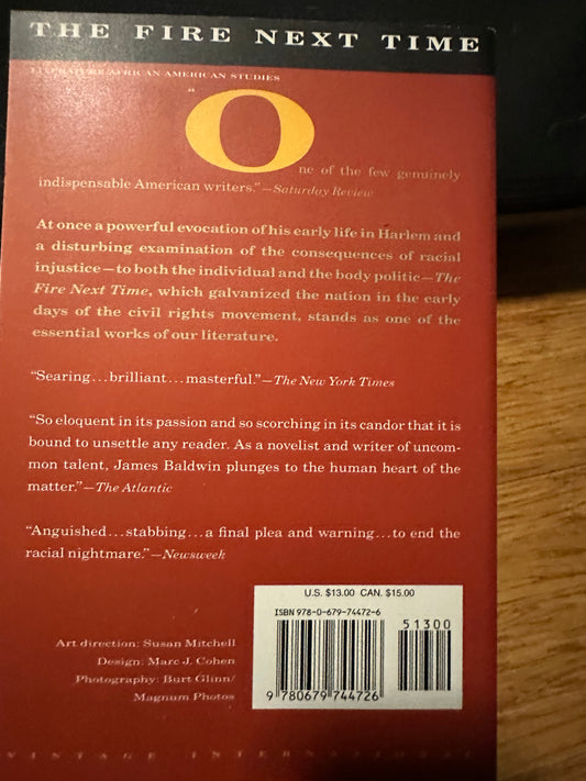 Back cover of The Fire Next Time by James Baldwin, featuring reviews and pricing details.