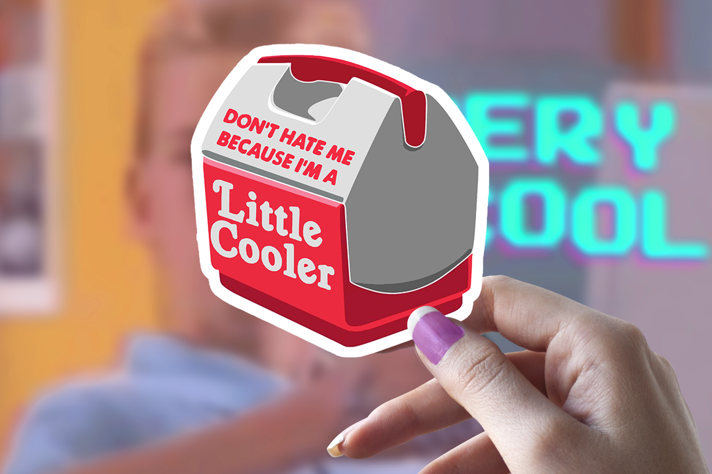 Hand holding sticker with Little Cooler text and humorous message.