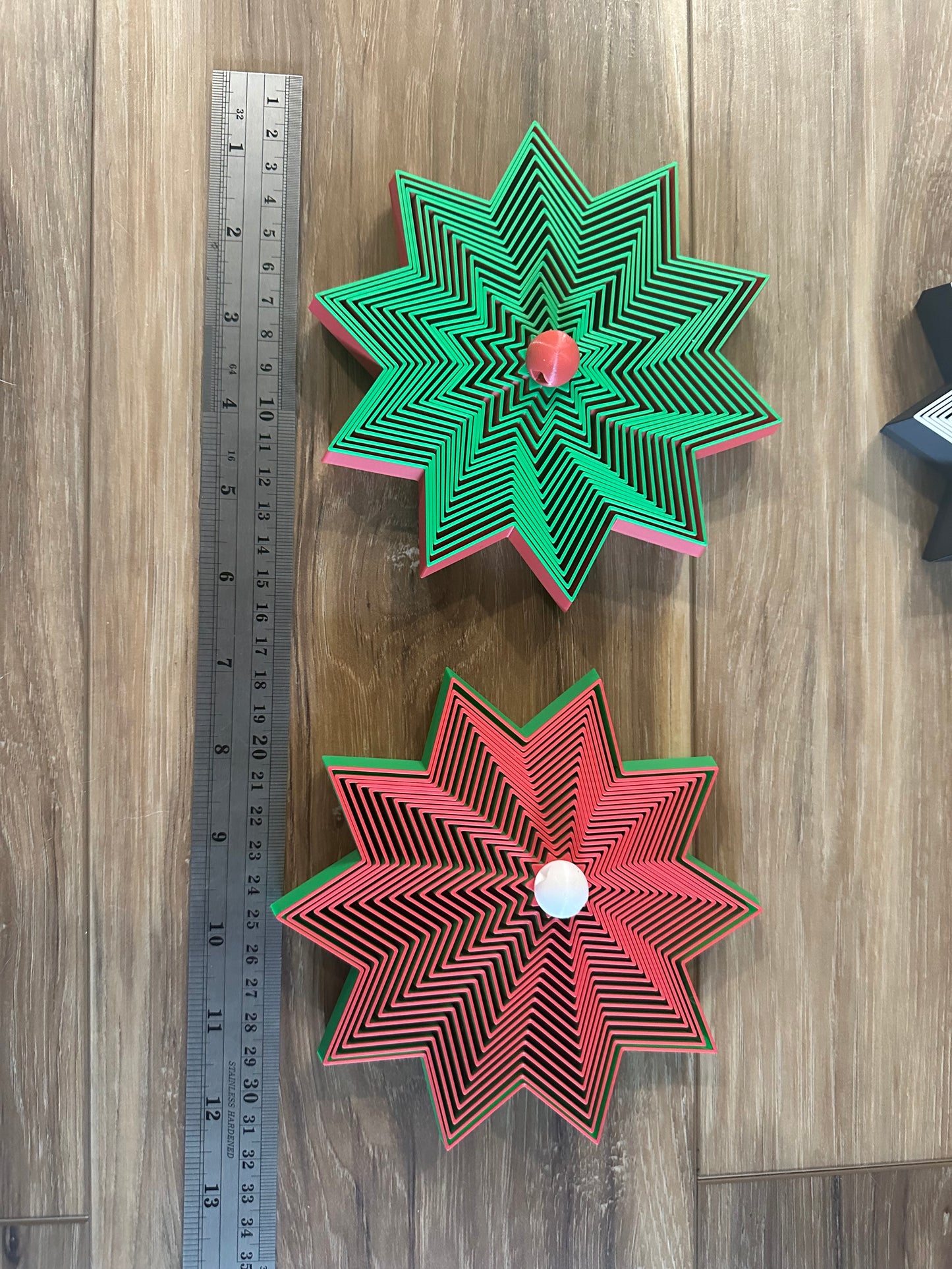 Green and red layered star ornaments with ruler for scale.