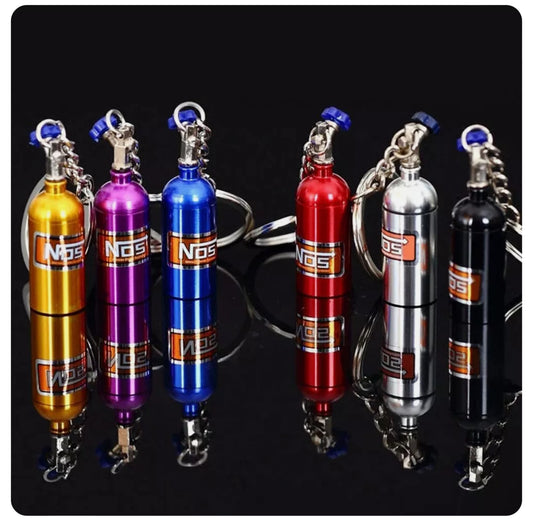 Mini NOS nitrous oxide canister keychains in various colors.