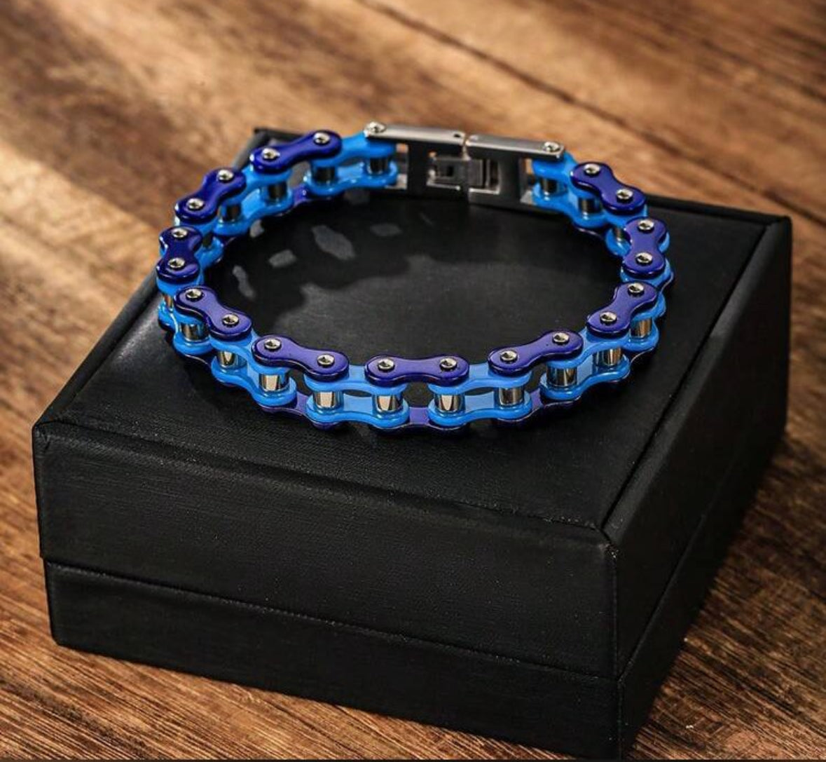Blue and purple motorcycle chain bracelet on black box.