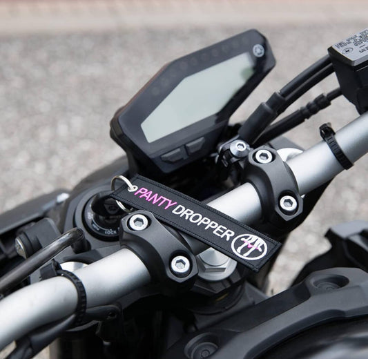 Motorcycle handlebar with Panty Dropper keychain attached.