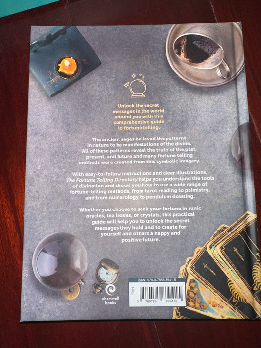 Back cover of The Fortune Telling Directory book with tarot cards, crystal ball, candle, and spoon.