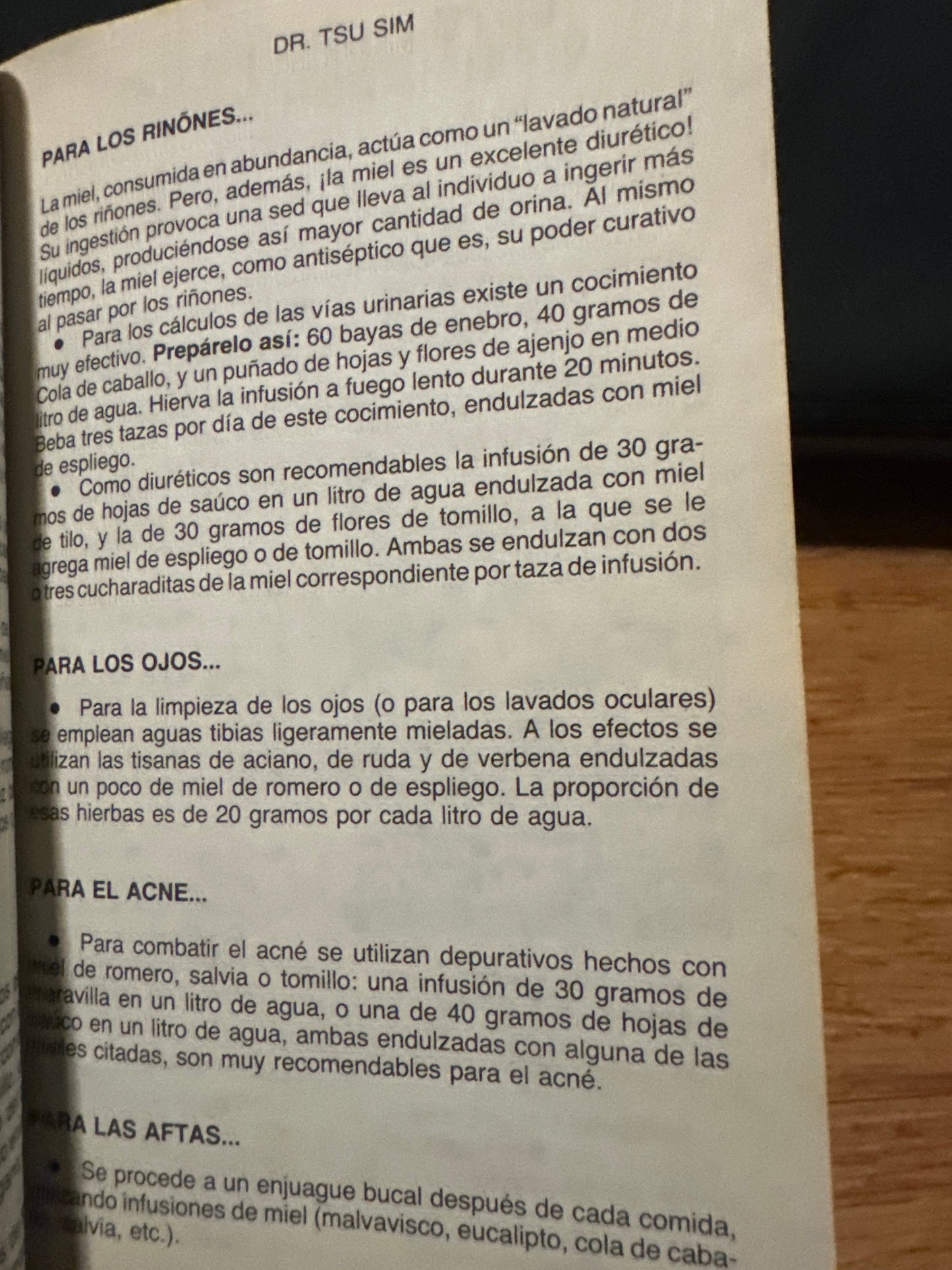 Page from a book with herbal remedies for kidney, eye, acne, and mouth sores in Spanish.