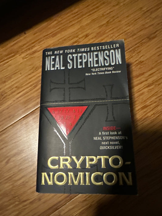 Neal Stephensons Cryptonomicon book cover on wooden surface.