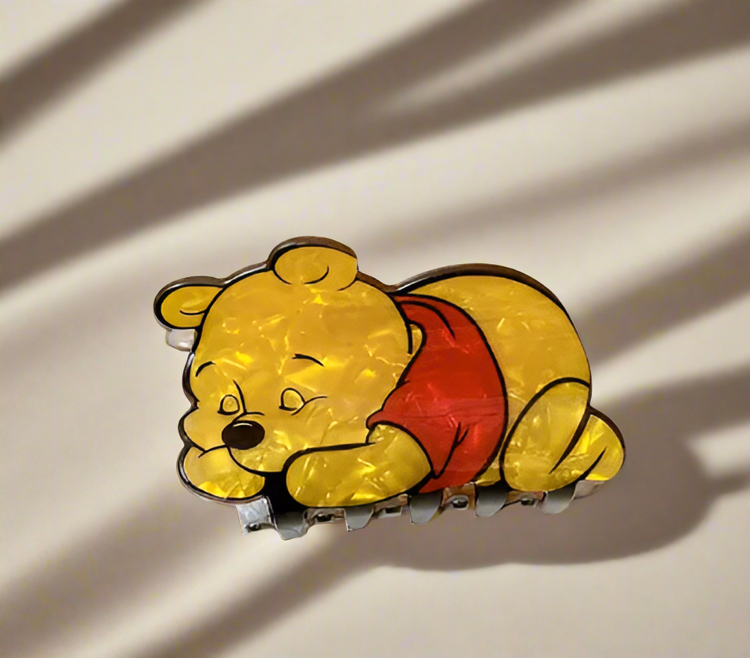 Winnie the Pooh enamel pin with red shirt, lying down.