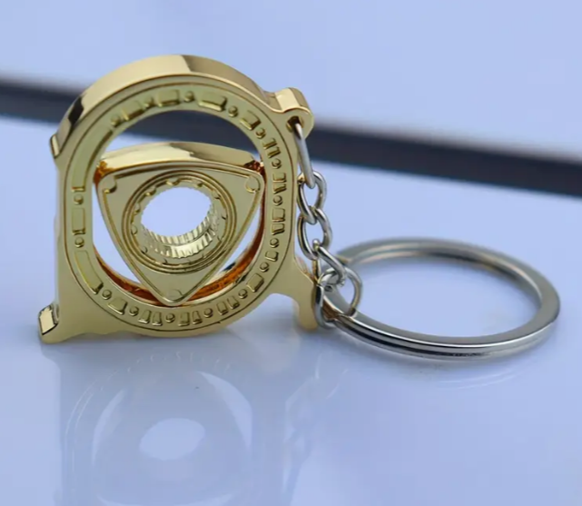Golden gear design keychain with intricate mechanical details.