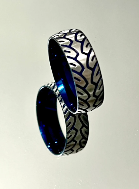 Two interlocking rings with intricate patterns and blue accents.