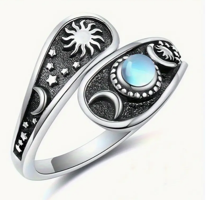 Silver ring with moonstone and celestial symbols.