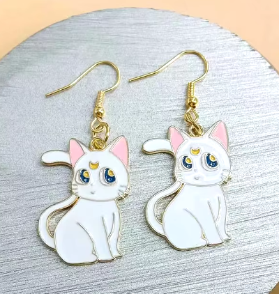 White cat earrings with pink ears and blue eyes on a gold hook.
