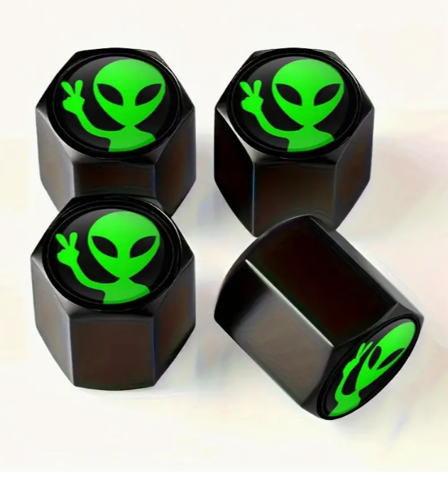 Black tire valve caps with green alien peace sign design.