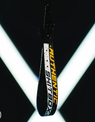 Black lanyard with AUTHENTIC SHITBOX text against neon lights.