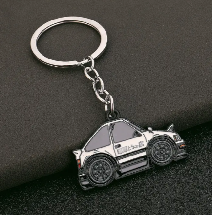 Silver car-shaped keychain with black details and Japanese text.