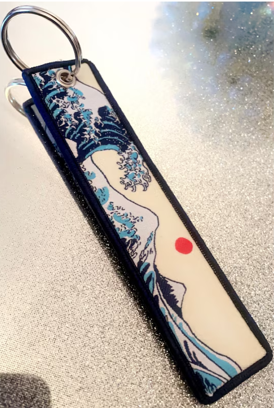 Keychain featuring The Great Wave off Kanagawa with a red sun.