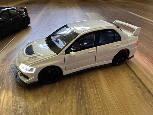 White die-cast toy car with black wheels on wooden surface.