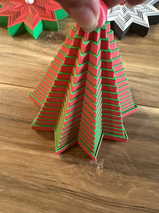 Red and green paper Christmas tree ornament with zigzag pattern.