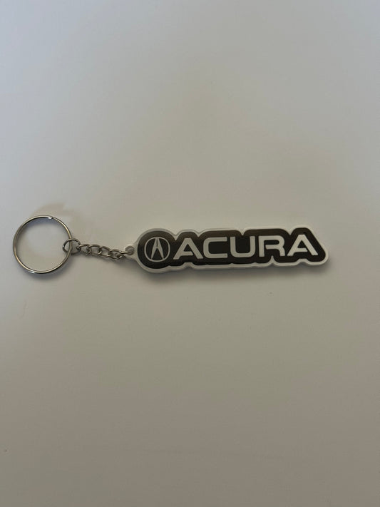 Acura logo keychain with silver ring on a plain background.