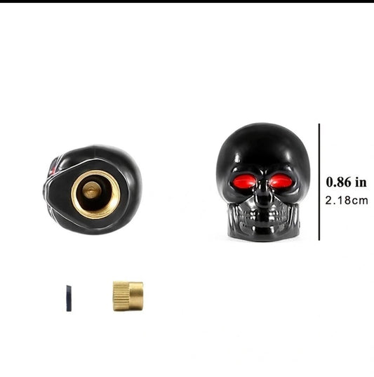 Black skull tire valve caps with red eyes and gold accents.