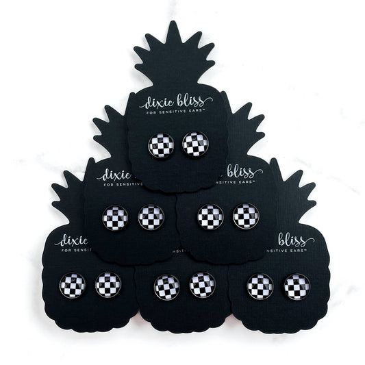 Black pineapple-shaped display with checkered earplugs by Dixie Bliss.