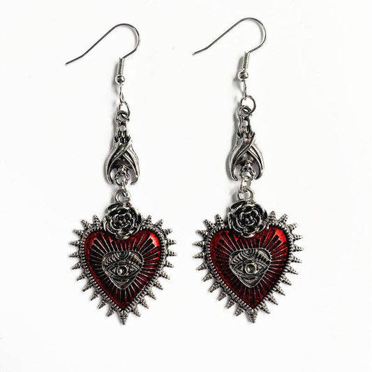 Gothic red heart earrings with silver accents and eye detail.