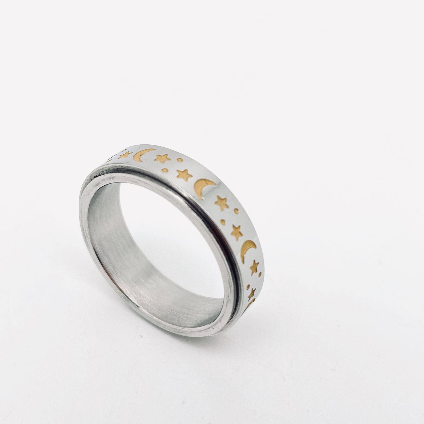 Silver ring with gold moon and star designs.