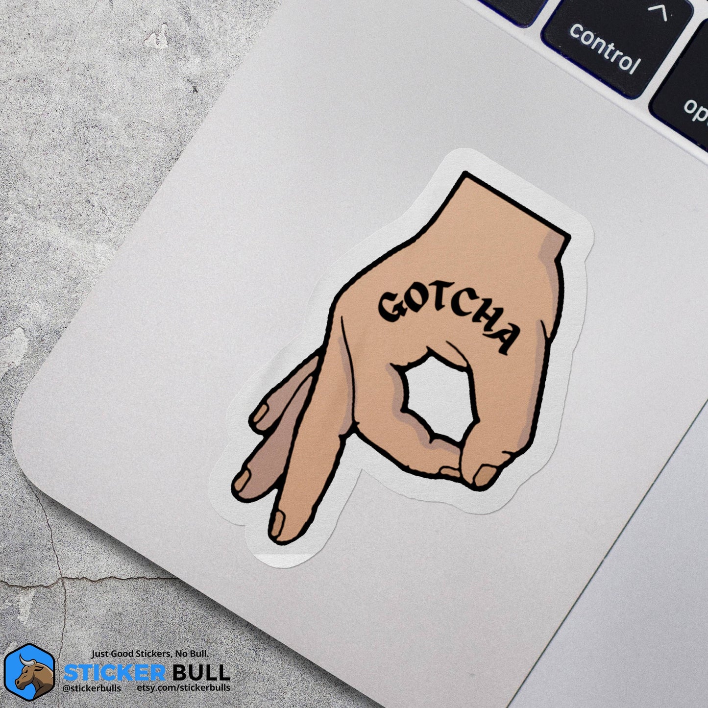 Gotcha hand gesture sticker on laptop keyboard