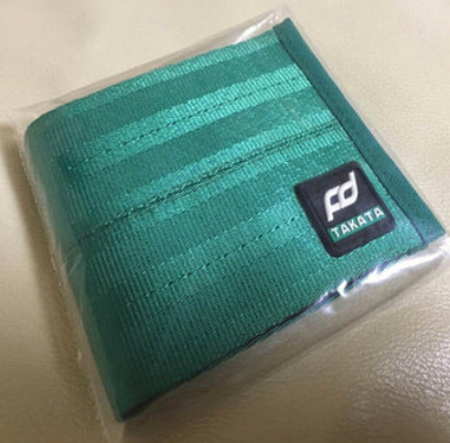 Teal striped Takata racing harness webbing in packaging.