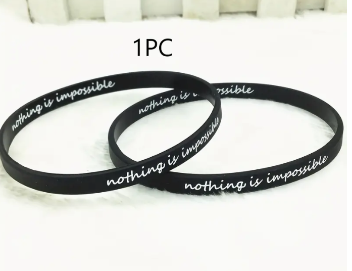 Black nothing is impossible wristband with white text.