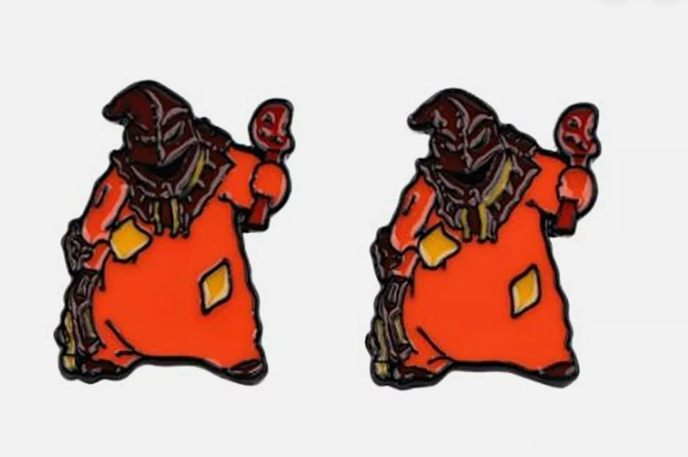 Two orange wizard enamel pins with a dark hood and staff.