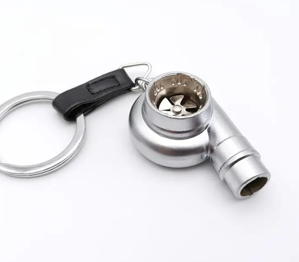 Silver metal keychain with a grinder attachment and black strap.