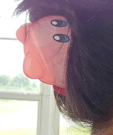 Person wearing a transparent face shield with cartoon eyes design.