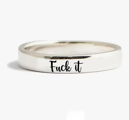 Silver ring with Fuck it engraved in cursive script.