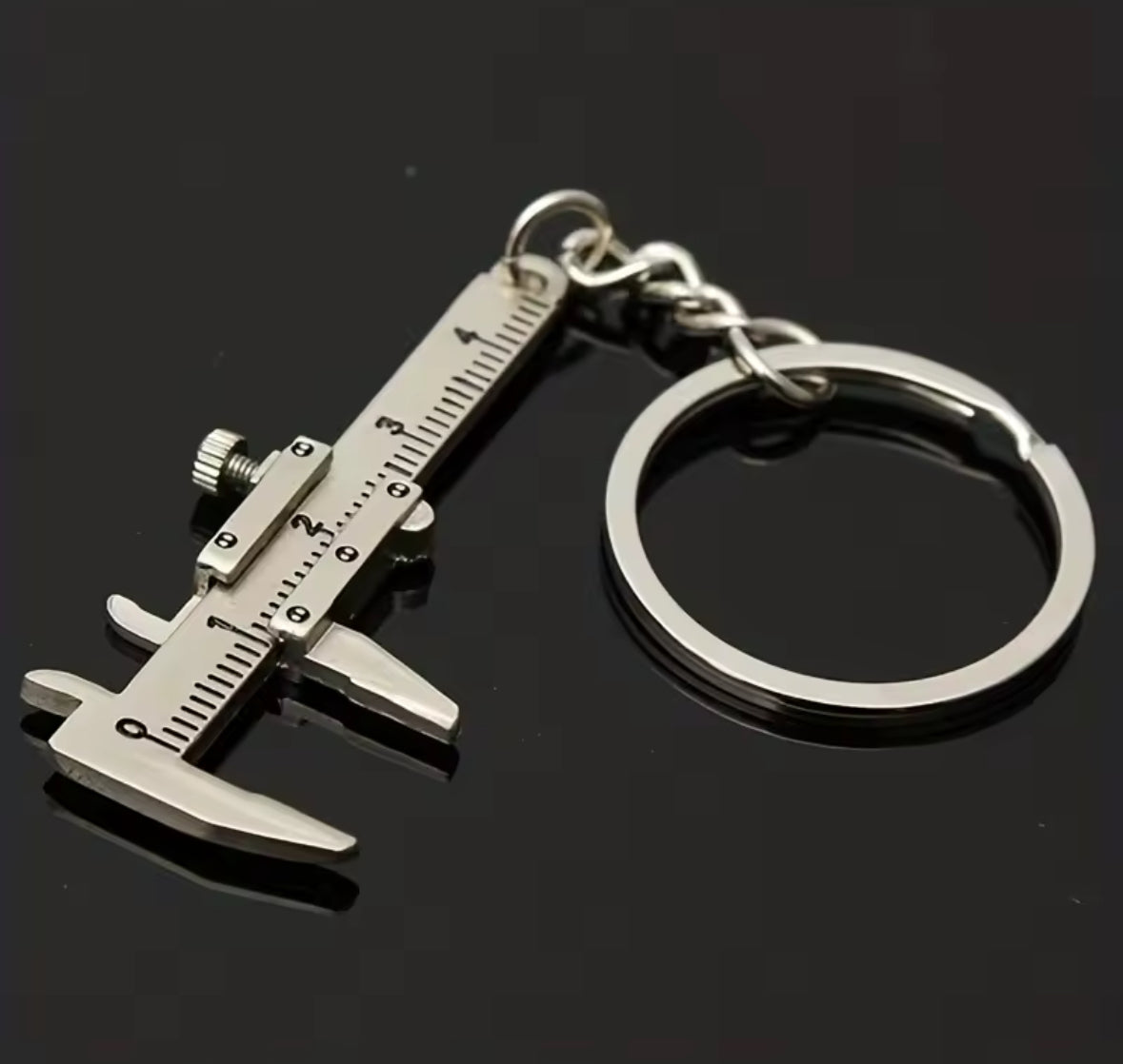 Miniature caliper keychain with ruler and ring, compact measurement tool.