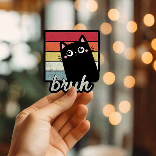 Hand holding a sticker with a cute black cat and bruh text on a colorful background.