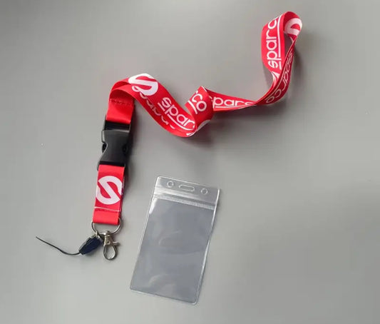 Red lanyard with spar logo and clear ID holder on gray background.